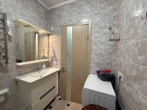 a bathroom with a sink and a toilet and a mirror at Apart 26 in Odesa +143 photos