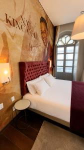 a bedroom with a large bed with a painting on the wall at Vila Galé Collection Opera - Sao Luis in São Luís
