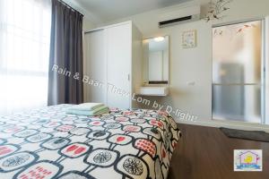 1 dormitorio con 1 cama con colcha colorida en Baan Thew Lom by D-light en Cha Am
