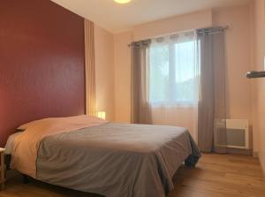 a bedroom with a bed and a window at La Maison du Bocage in Saint-Mesmin