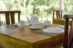 丹不拉Sun and Green Eco Lodge - Dambulla的一张木桌,上面放着茶具