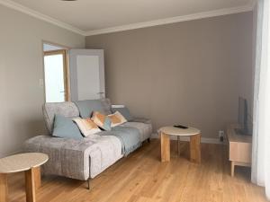 a living room with a couch and two tables at La Maison du Bocage in Saint-Mesmin