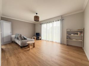 an empty living room with a couch and a table at La Maison du Bocage in Saint-Mesmin