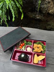 a red tray with a plate of food on a table at Towa Onsen and Ryokan in Ban Nong Tangme