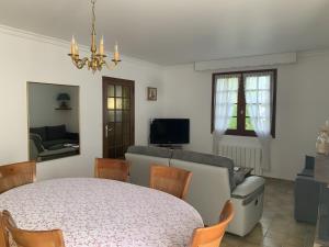 a living room with a table and chairs and a couch at Chez Martine Et Michel in Pléneuf-Val-André