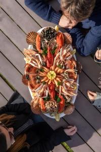 a group of people standing around a plate of seafood at Chez Martine Et Michel in Pléneuf-Val-André +19 photos