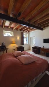 a bedroom with a large bed in a room with wooden ceilings at Cloffy et son Domaine in Nouans-les-Fontaines