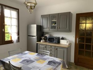 a kitchen with a table and a refrigerator at Chez Martine Et Michel in Pléneuf-Val-André