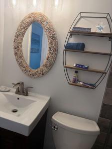 a bathroom with a sink and a mirror and a toilet at Beach Bum Bungalow in Jensen Beach +27 photos
