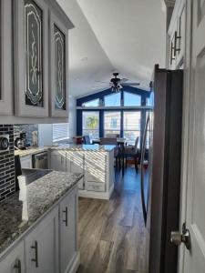 a kitchen with white cabinets and a dining room at Beach Bum Bungalow in Jensen Beach