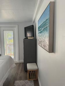 a bedroom with a bed and a tv on a wall at Beach Bum Bungalow in Jensen Beach
