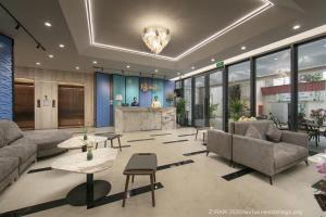 a lobby with couches and tables in a building at Noi Bai Horizon Hotel & Spa in Noi Bai