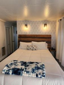 a large white bed with a blanket on top of it at Beach Bum Bungalow in Jensen Beach