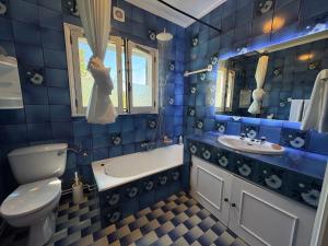 a blue tiled bathroom with a toilet and a sink at Moledo Seaview in Moledo +90 photos