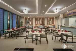 a restaurant with tables and chairs and a bar at Noi Bai Horizon Hotel & Spa in Noi Bai