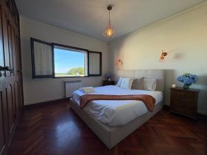 a bedroom with a large bed and a window at Moledo Seaview in Moledo