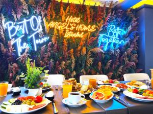 a table with plates of food and neon signs at Angel's Home Hotel - Angel Group Hotels in Istanbul