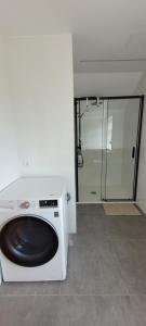 a white washing machine in a bathroom with a shower at Apartamento Camariñas in Camariñas