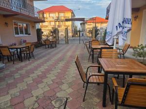 an outdoor patio with tables and chairs and an umbrella at La Camuflaj 2 Mai in 2 Mai