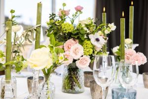 a table with vases filled with flowers and candles at L’Horizon Beach Hotel & Spa in St. Brelade +48 photos