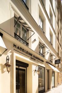 a building with a sign for a hotel at Hôtel Madeleine Haussmann in Paris