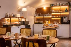 a restaurant with tables and chairs and a kitchen at Hôtel Madeleine Haussmann in Paris