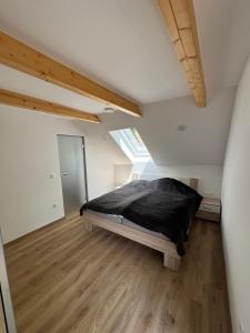 a bedroom with a bed with a black blanket at Apartma Pr`mejač in Laze v Tuhinju