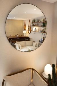a living room with a white couch and a mirror at Hôtel Madeleine Haussmann in Paris +80 photos