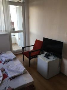 a living room with a tv and a chair at Къща Йорданови in Chernomorets