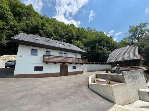 a large white building with a fence and trees at Apartma Pr`mejač in Laze v Tuhinju