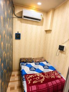 a small bedroom with a bed and a air conditioner at hotel shree guru pandey in Indore