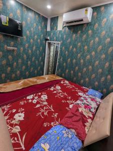 a bedroom with a bed with a red blanket at hotel shree guru pandey in Indore