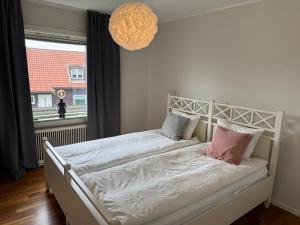 a bedroom with a white bed and a window at Hardangegatan in Östersund