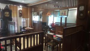 a restaurant with tables and chairs and a clock at Sakura building hotel & restaurand in Hải Dương