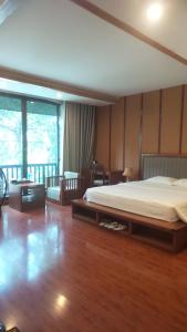 a bedroom with a bed and a wooden floor at Sakura building hotel & restaurand in Hải Dương