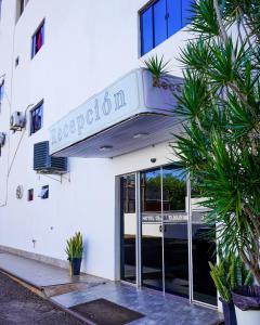 a white building with a sign for a hotel at Hotel Ciudad Nueva in Ciudad del Este