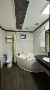 a bathroom with a tub and a toilet and a sink at Sakura building hotel & restaurand in Hải Dương +49 photos