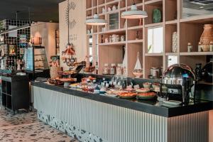 a restaurant with a counter with food on it at ibis Martigues Centre in Martigues