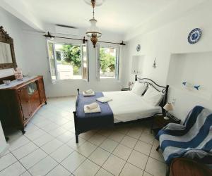 a bedroom with a bed and a chair in it at Yiayia's guesthouse in Skopelos Town
