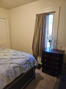 a bedroom with a bed and a dresser with a window at Plantlife LLC A in Minneapolis +1 photo