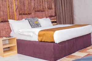 a large bed in a room with at Indian Atlantic Hotel & Suites in Agbor