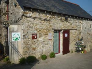 an old stone building with a red door at L'ânesque in Saint-Augustin-des-Bois