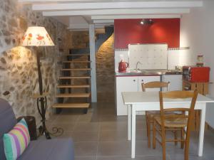 a kitchen with a table and a dining room at L'ânesque in Saint-Augustin-des-Bois