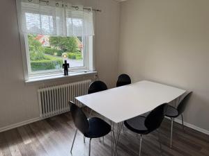 a white table and chairs in a room with a window at Hardangegatan in Östersund +6 photos