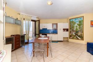 a kitchen and dining room with a table and chairs at Casa Pia in Valledoria +17 photos
