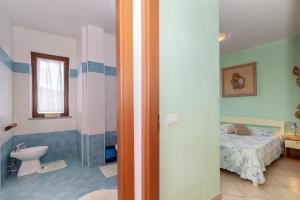 a bedroom with a bed and a bathroom with a toilet at Casa Pia in Valledoria