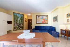 a living room with a table and a blue couch at Casa Pia in Valledoria