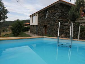 a villa with a pool in front of a house at Casa da Colina in Amarante