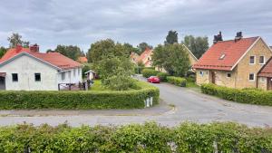 a village with houses and a red car on a road at Hardangegatan in Östersund