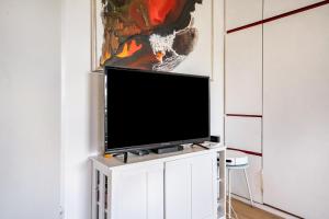 a television on a white cabinet in a living room at Ferienappartement in Black Forest in Baiersbronn